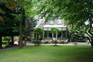 uma casa com cadeiras e mesas num quintal em Hotel Beukenhorst em Wittem