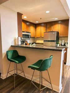 a kitchen with two green chairs at a counter at Stylish Apartment in the Heart of Los Angeles in Los Angeles