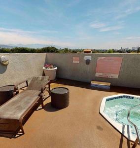 a patio with a bench and a hot tub on a roof at Stylish Apartment in the Heart of Los Angeles in Los Angeles