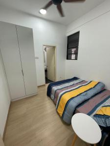 Un dormitorio con una cama y una mesa. en Family Cozy Homestay - Alpha IVF at Strand Mall, en Petaling Jaya