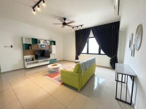 un salon avec une chaise verte et une télévision dans l'établissement Family Cozy Homestay - Alpha IVF at Strand Mall, à Petaling Jaya