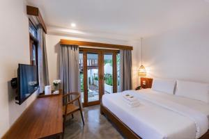 sypialnia z dużym białym łóżkiem i telewizorem w obiekcie Phang Nga Origin Hotel w mieście Phangnga