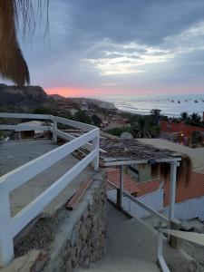 a view of the beach from a white fence at Bungalows Bella Vista in Zorritos