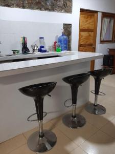 a counter with two black bar stools in a kitchen at Bungalows Bella Vista in Zorritos