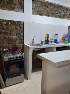 a kitchen with a stove and a counter and a sink at Bungalows Bella Vista in Zorritos