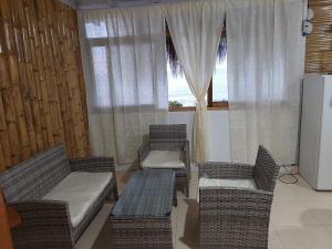 a living room with two chairs and a couch and a window at Bungalows Bella Vista in Zorritos