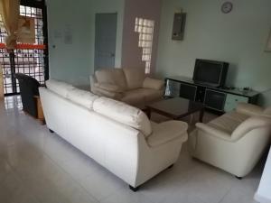 a living room with a couch and chairs and a tv at Homestay HARAPAN in Muar