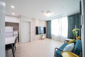 een woonkamer met een blauwe bank en een televisie bij Sai in Daejeon