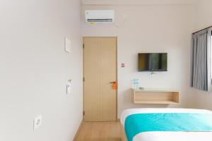 Ένα ή περισσότερα κρεβάτια σε δωμάτιο στο Sans Hotel Clover Ace Surabaya by RedDoorz
