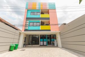 un edificio con una fachada colorida delante de él en Sans Hotel Clover Ace Surabaya by RedDoorz en Surabaya