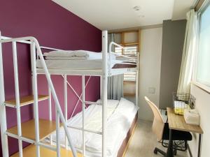 a room with two bunk beds and a desk at Hotel Mikado in Osaka