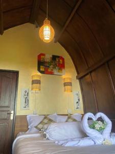 a bedroom with a bed with a swan on it at Pondok Ganesha Bali in Gitgit