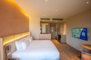 Habitación de hotel con cama y TV en Centara Ubon en Ubon Ratchathani