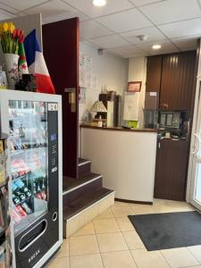 a kitchen with a drink cooler in a store at Hotel Luna Park in Paris