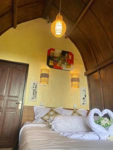 Pondok Ganesha Bali في Gitgit: غرفة نوم عليها سرير وبجعة