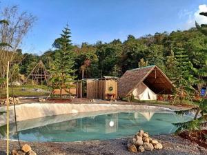 un complexe avec une tente et une piscine dans l'établissement Yellowstone Camps Resort Khao Yai, à Pak Chong