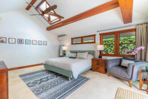 a bedroom with a bed and a chair at Makana Lei in Princeville +29 photos