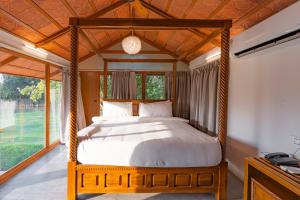 a bedroom with a canopy bed with a large window at Brown Town Resort & Spa in Hyderabad