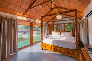 a bedroom with a bed and a large window at Brown Town Resort & Spa in Hyderabad