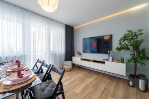 a living room with a dining table and a television at Golden Sands in Łódź