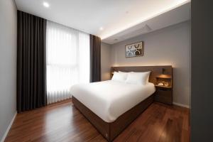 1 dormitorio con cama blanca y ventana en Le Collective Gangnam SAC Signity en Seúl