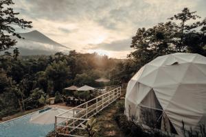a tent next to a pool with a mountain in the background at Domeino Dome Suites in Minnesota Hacienda