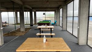 a row of picnic tables in a building with windows at Flyscape in Bīr