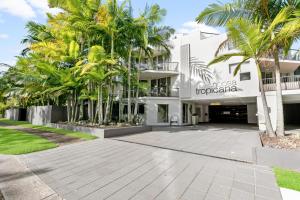 un gran edificio blanco con palmeras delante en Noosa Tropicana en Noosaville