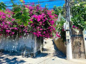 una calle con flores rosas colgando de una valla en Homestay Luna mountain & sea views! en Vung Tau