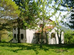 una casa blanca con un árbol en el patio en B&B Ca' Battista, en Montelungo Superiore