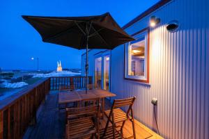 Okhotsk Ocean Villa AL MARE mombetsu في مونبيتسو: طاولة وكراسي خشبية على سطح السفينة مع مظلة