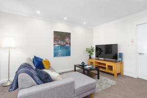 - un salon avec un canapé et une télévision dans l'établissement 309 Secret City Sanctuary Prkingpoolview, à Perth