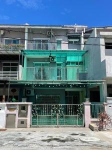 a green building with a fence in front of it at Countryside Homestay in Sekincan +35 photos