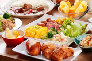 una mesa de madera con platos de comida. en Sotetsu Fresa Inn Tokyo Kinshicho en Tokio