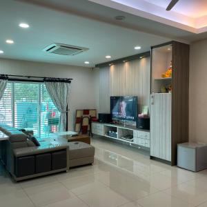 a living room with a couch and a tv at Countryside Homestay in Sekincan