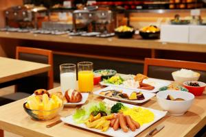 a table with plates of food and glasses of orange juice at Sotetsu Fresa Inn Tokyo Kinshicho in Tokyo