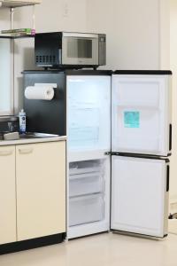 2 weiße Kühlschränke in einer Küche mit Mikrowelle in der Unterkunft SAPPHIRE -SEVEN Hotels and Resorts- in Okinawa