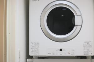 a washing machine with a window on a wall at SAPPHIRE -SEVEN Hotels and Resorts- in Okinawa City