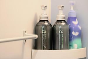 SAPPHIRE -SEVEN Hotels and Resorts- في أوكيناوا سيتي: ثلاث زجاجات مياه في حامل في الحمام