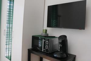 a microwave on a table with a tv on a wall at Haus M&M in Brixen im Thale