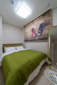 a bedroom with a bed with a green blanket at Comma in Daejeon