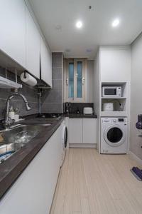 a kitchen with a sink and a washing machine at Comma in Daejeon