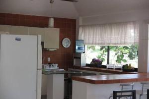 een keuken met een koelkast en een aanrecht bij Casa en Teques con alberca, vista y acceso al lago in Tequesquitengo
