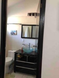 een badkamer met een wastafel, een toilet en een spiegel bij Casa en Teques con alberca, vista y acceso al lago in Tequesquitengo