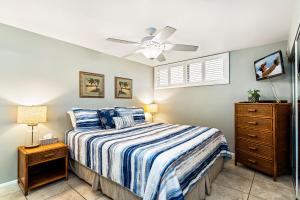 a bedroom with a bed and a ceiling fan at Sea Village 1105 in Kailua-Kona +23 photos