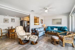 a living room with a blue couch and chairs at Casa De Emdeko 235 in Kailua-Kona