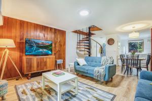 a living room with a blue couch and a table at Cedar Cottage Unit 5 in Bright