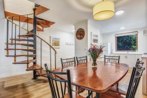 a dining room with a table and chairs and a spiral staircase at Cedar Cottage Unit 5 in Bright