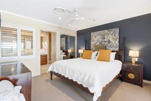 a bedroom with a large white bed with yellow pillows at Vistablue @ the Bay in Urangan