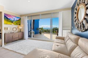 a living room with a couch and a large window at Vistablue @ the Bay in Urangan